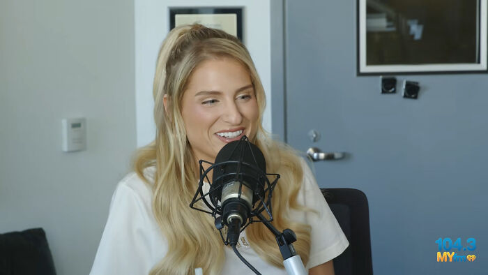 A female celebrity whose fame ran out, smiling while speaking into a microphone.