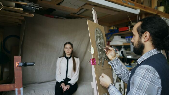 An artist sculpting a bust of a woman, a unique and creative way to earn money.