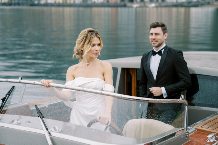 Bride and groom in wedding attire on a boat during wedding weekend getaway Bride and groom in wedding attire on a boat during wedding weekend getaway