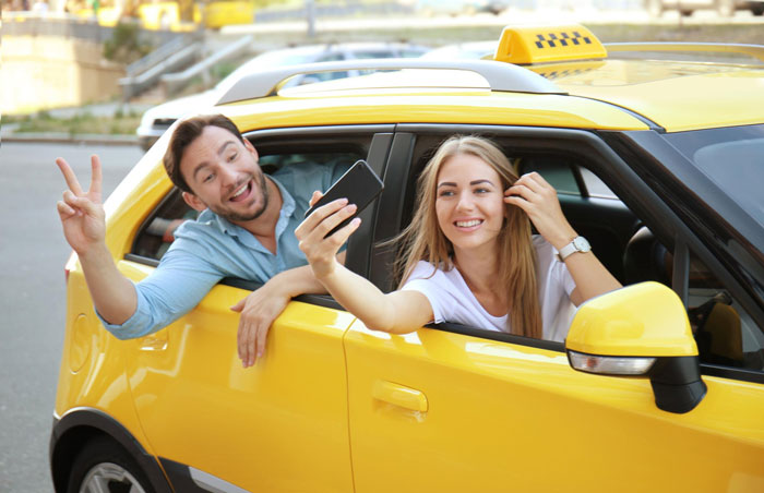 Couple takes selfie in yellow taxi during wedding getaway Couple takes selfie in yellow taxi during wedding getaway