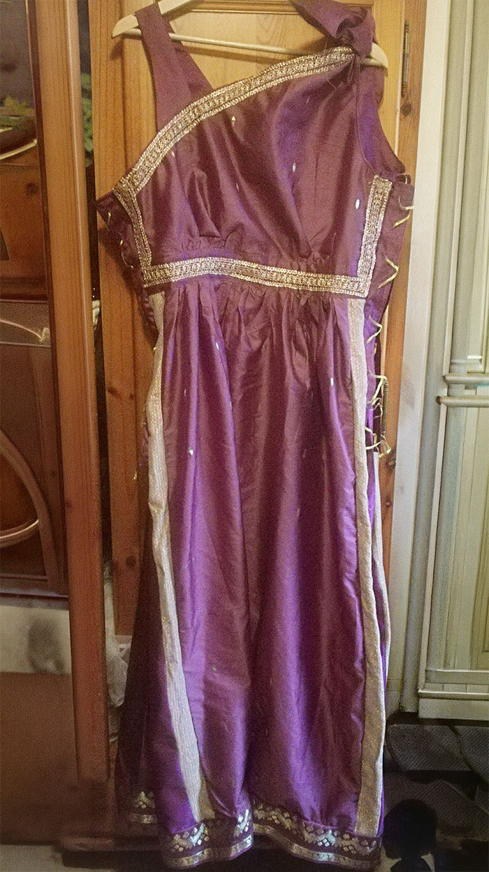 Purple elaborate wedding dress hanging on wooden door