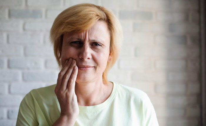 Woman clutching her jaw, distressed, experiencing a missing tooth or family drama from a bachelorette party. Woman clutching her jaw, distressed, experiencing a missing tooth or family drama from a bachelorette party.