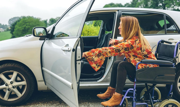 Woman in wheelchair trying to get into car illustrating ableist relationship challenges Woman in wheelchair trying to get into car illustrating ableist relationship challenges