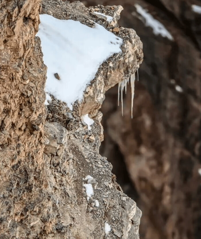 Snow and icicles on rocky cliff showing natural hidden details