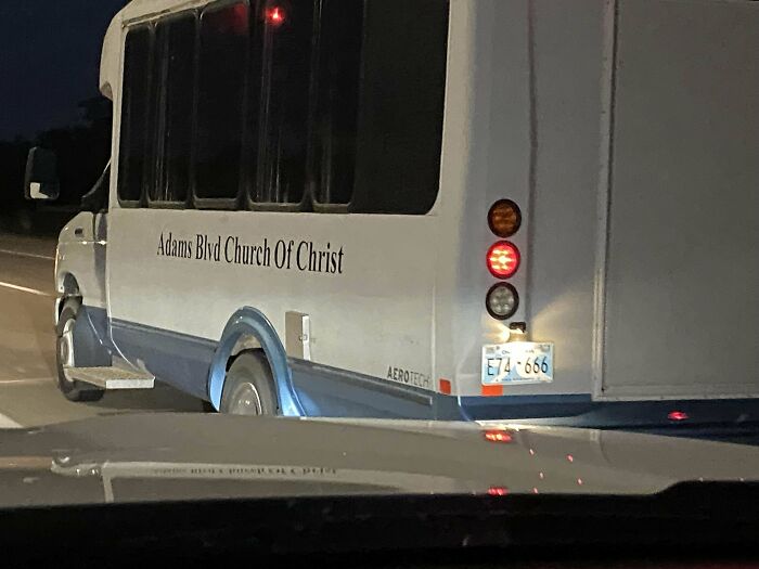 Church bus at night with red brake lights on a dark road