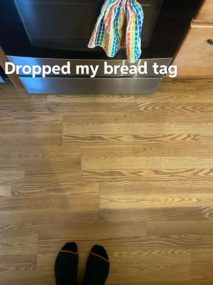View of hardwood floor with feet visible and text dropped bread tag