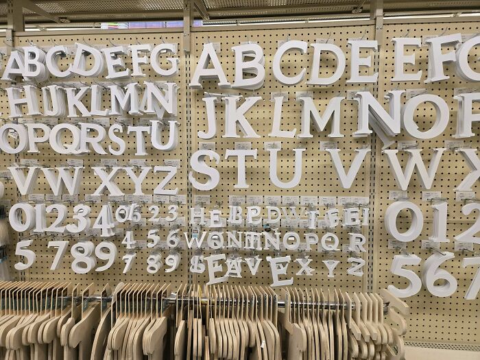White plastic alphabet and number letters on pegboard wall in craft store