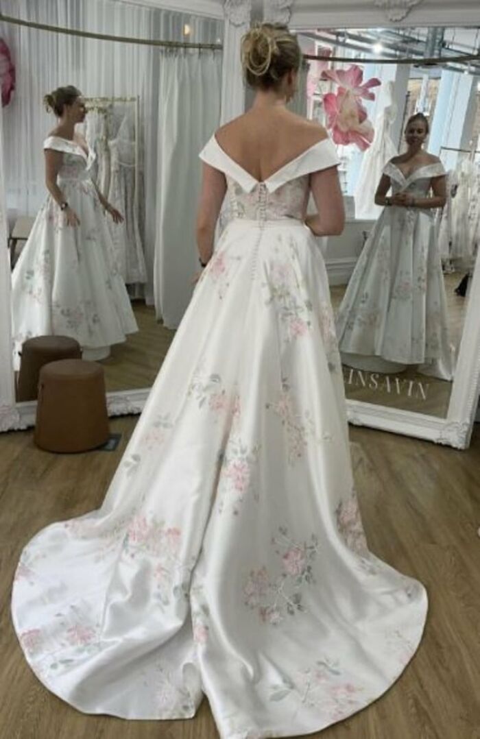 Woman wearing a floral pattern bridal gown reflected in multiple mirrors