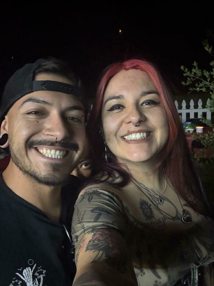 Night selfie of a smiling couple and a hidden face peeking between them for online detectives
