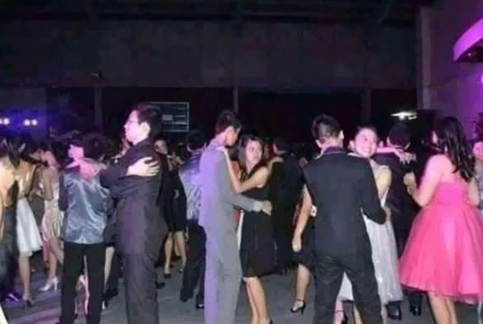 A crowded dance floor scene with couples dancing, one man in the foreground appears to be embracing himself. A funny 'When You See It' photo.