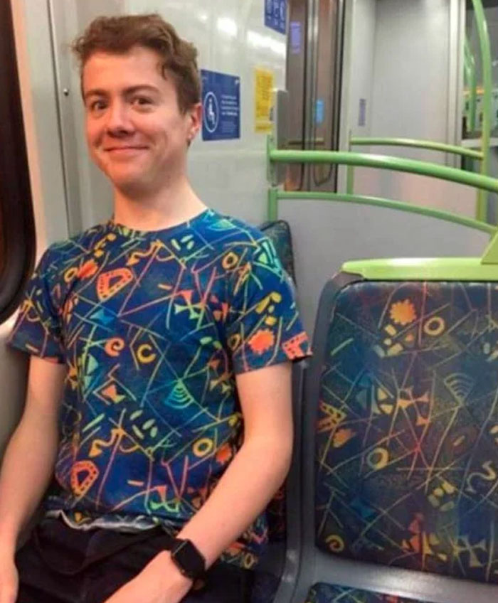 A young man in a patterned shirt on a train, blending with the seat pattern in this 'When You See It' photo.