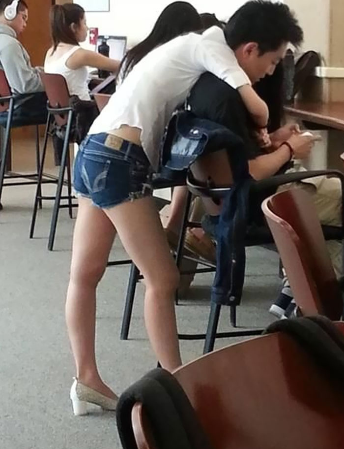A girl piggybacking a boy in a room full of people. This 'When You See It' picture is short-circuiting brains.