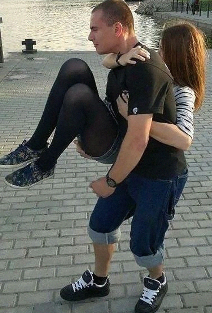 Man carrying a woman who appears to be wearing very large shoes and pants. An amusing 'When You See It' picture.