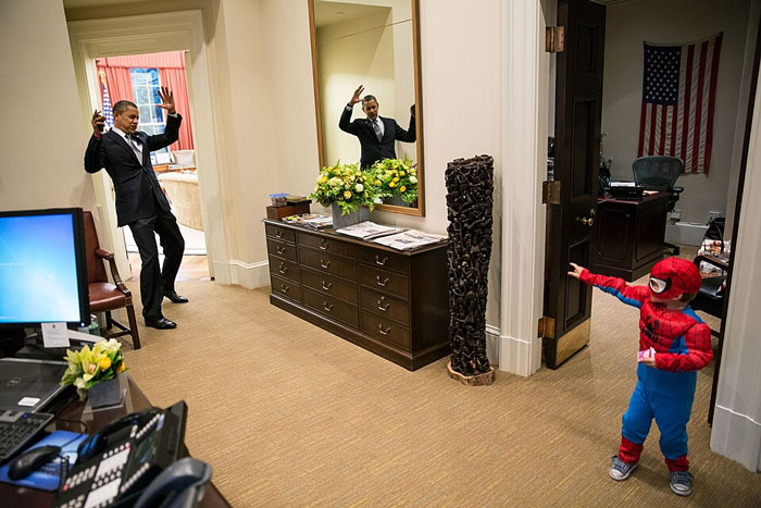 World leader playing with child dressed as Spider-Man in an office