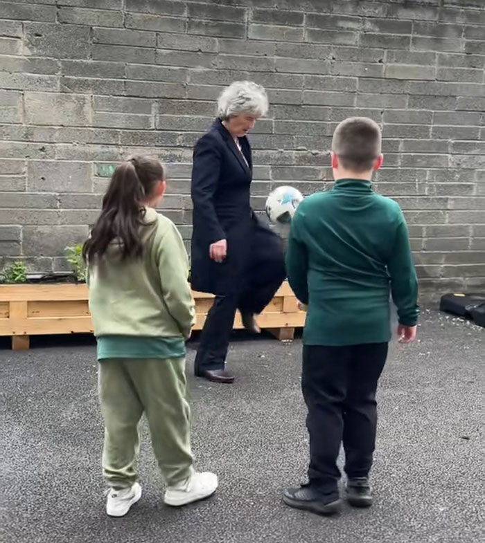 World leader playing soccer with children outdoors