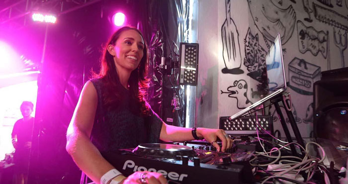 Female world leader DJing at event showing unique wholesome moment