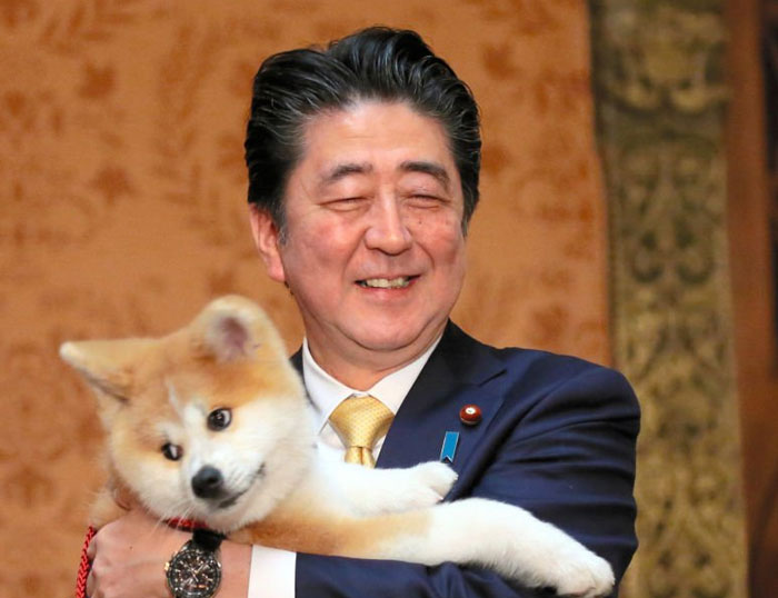 World leader holding a smiling dog showing wholesome moments of world leaders