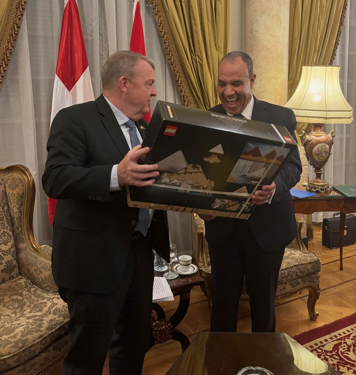 World leaders exchanging a joyful gift of LEGO set indoors