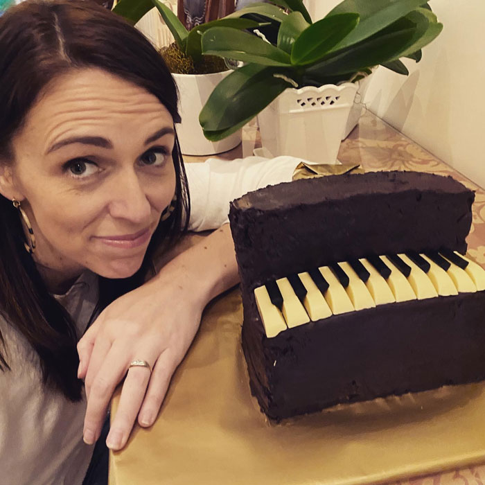 World leader posing with cake shaped like piano keyboard