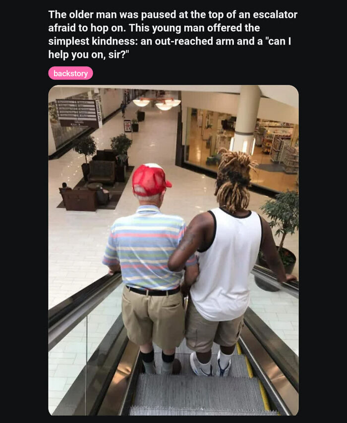 Young man offers arm to help older man on escalator showing kindness