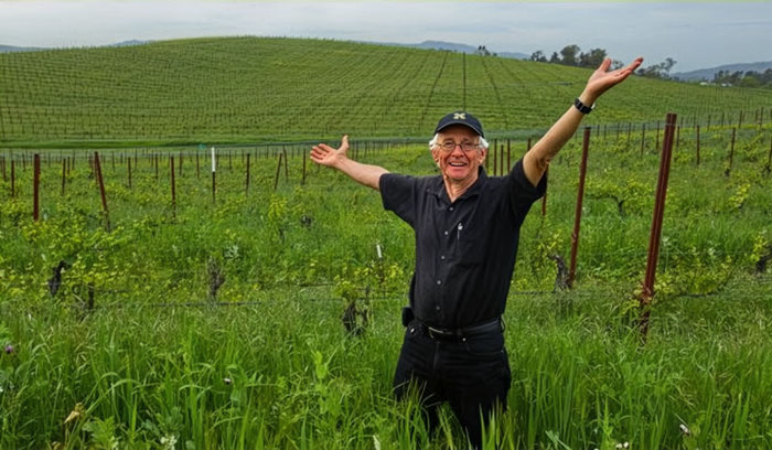 Photographer smiling in vineyard with green hill from most viewed photo ever Photographer smiling in vineyard with green hill from most viewed photo ever