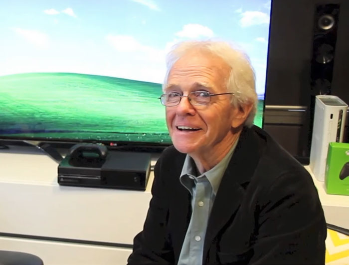 Man sitting indoors with most viewed photo ever image on TV screen behind Man sitting indoors with most viewed photo ever image on TV screen behind
