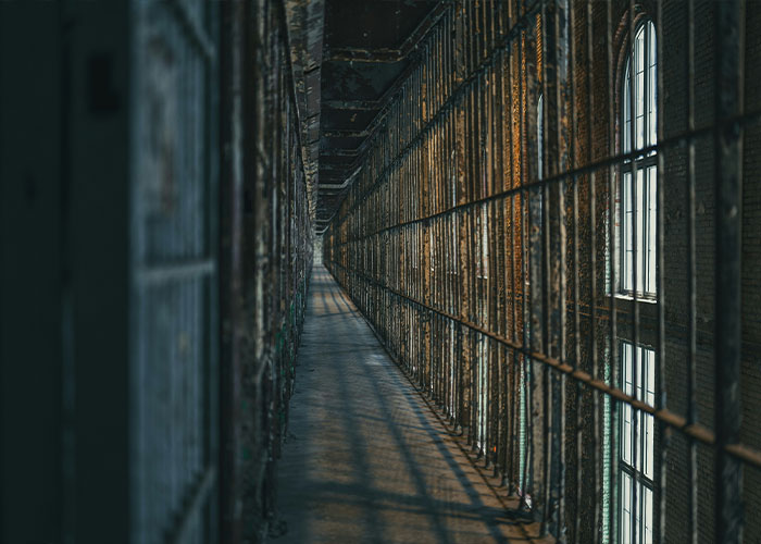 Rusty bars and narrow walkway inside an old abandoned prison corridor Rusty bars and narrow walkway inside an old abandoned prison corridor