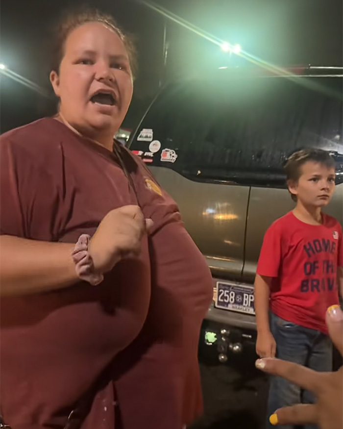 Woman arguing with child beside vehicle in hot car incident Woman arguing with child beside vehicle in hot car incident