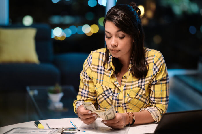 Bride counting money planning wedding budget at home