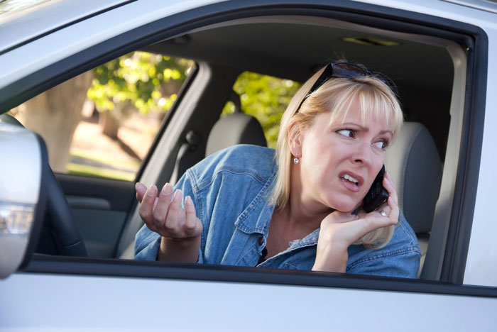 Concerned woman in car on phone about crash damage Concerned woman in car on phone about crash damage
