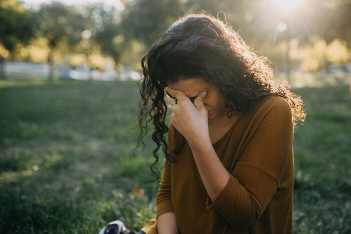 Woman wiping tears outdoors showing emotional pure generosity