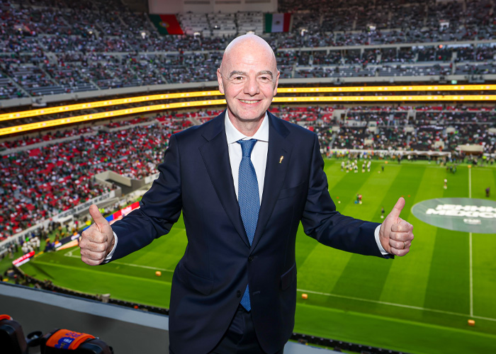 World Cup boss smiles in a soccer stadium, giving thumbs up amidst a soccer world scandal. World Cup boss smiles in a soccer stadium, giving thumbs up amidst a soccer world scandal.