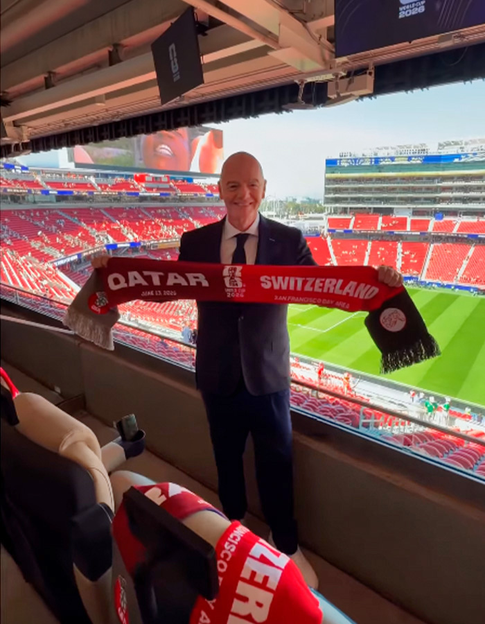 World Cup Boss at a stadium holding a Qatar-Switzerland scarf, highlighting the soccer scandal's hypocrisy. World Cup Boss at a stadium holding a Qatar-Switzerland scarf, highlighting the soccer scandal's hypocrisy.