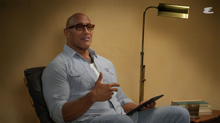 Muscular celebrity wearing glasses and blue shirt sharing a story about disappointing celebrity encounters