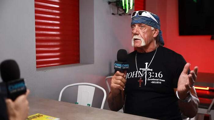 Man wearing John 3:16 shirt speaking during celebrity interview