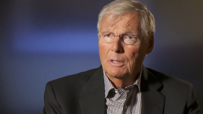Elderly man in suit sharing disappointing celebrity encounter story