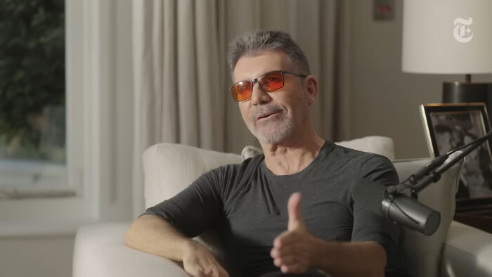 Man in glasses discussing disappointing celebrity encounters on podcast