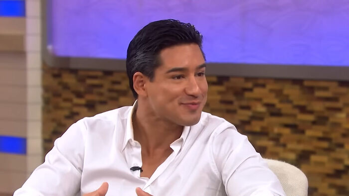 Smiling man in white shirt talking during celebrity encounters interview