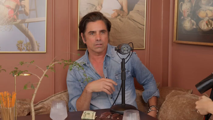 Man in denim shirt sharing his story on celebrity encounters podcast