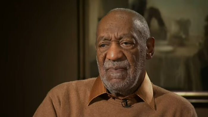 Close-up of a serious celebrity in a brown sweater discussing disappointing celebrity encounters