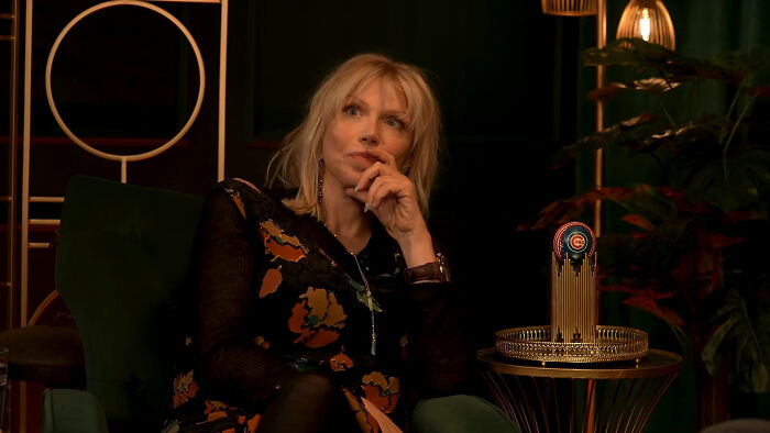 Blonde woman in patterned dress pondering celebrity encounters