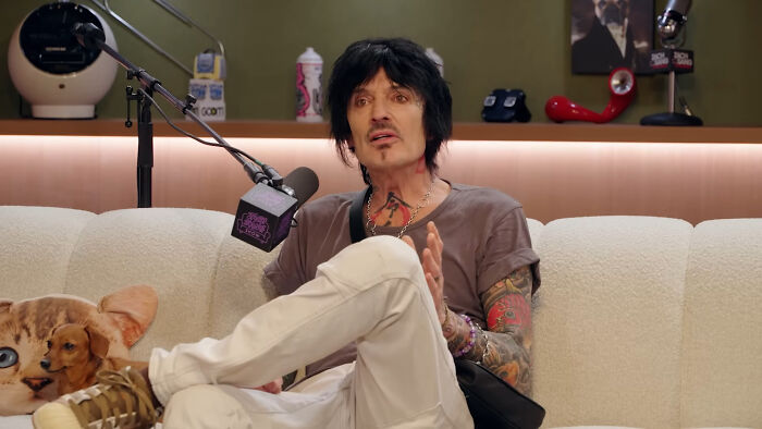 Man with black hair and tattoos sharing stories in celebrity encounters podcast