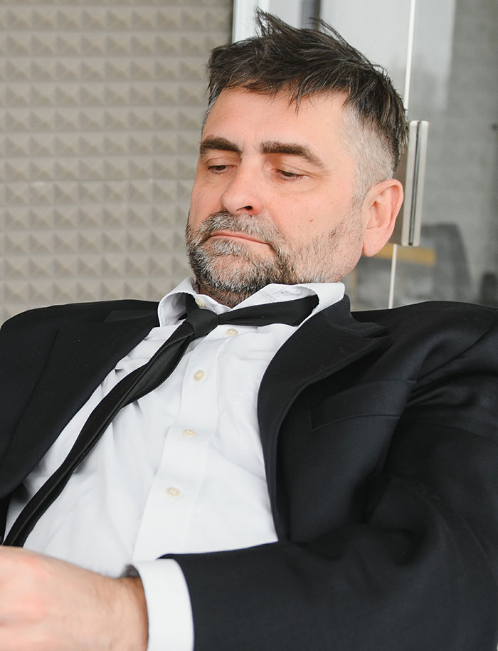 Tired man in suit and tie looking down depicting fired employees emotions
