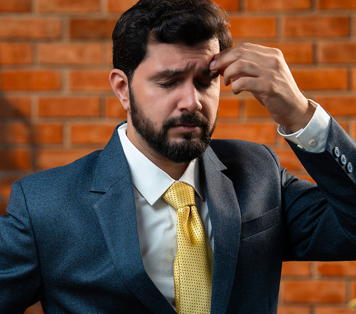 Stressed businessman in suit reacting to ridiculous firing news