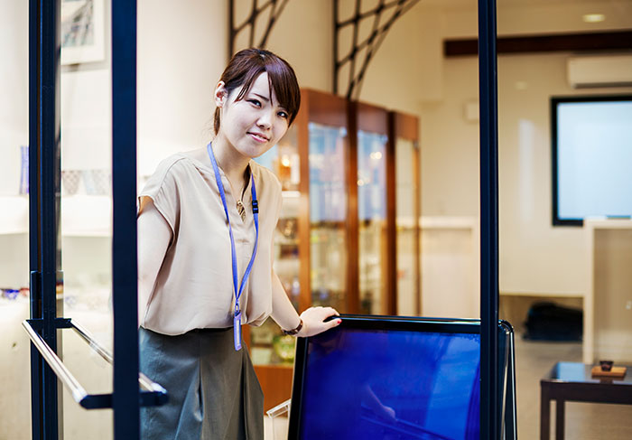 Young woman opening door in office depicting workplace scenarios of firing employees