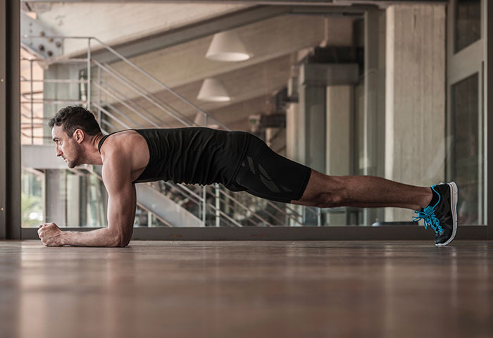 Man exercising indoors illustrating fitness habits of employees fired for silly reasons