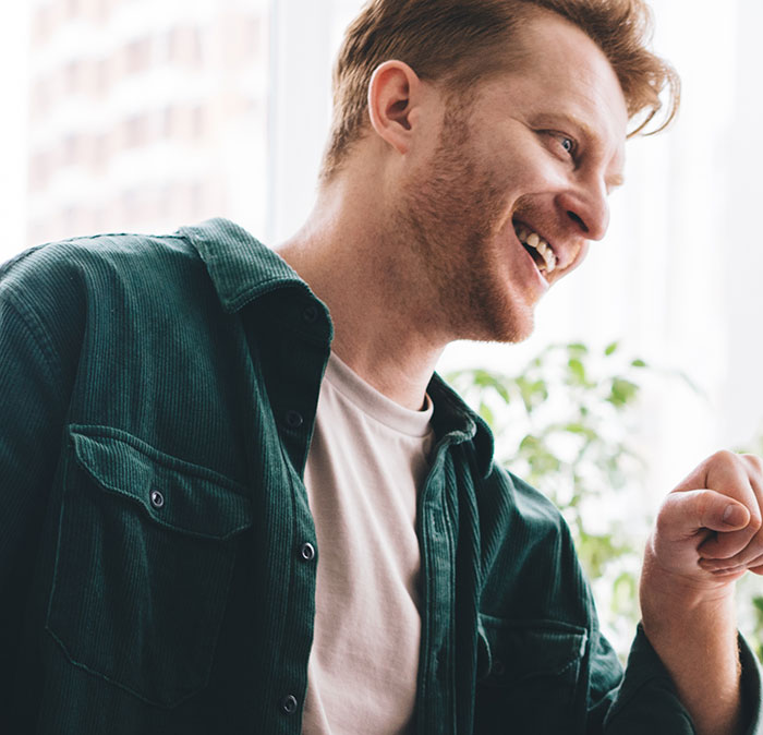 Laughing man in green jacket depicting employees fired for silly reasons