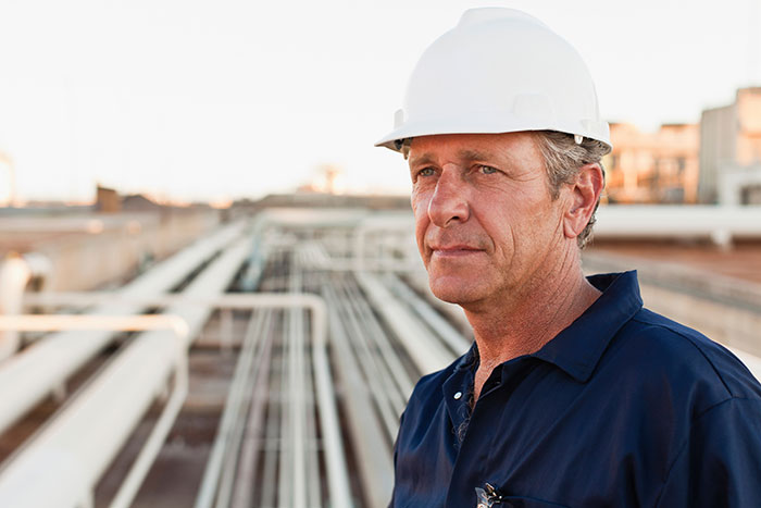 Construction worker wearing white helmet at industrial site