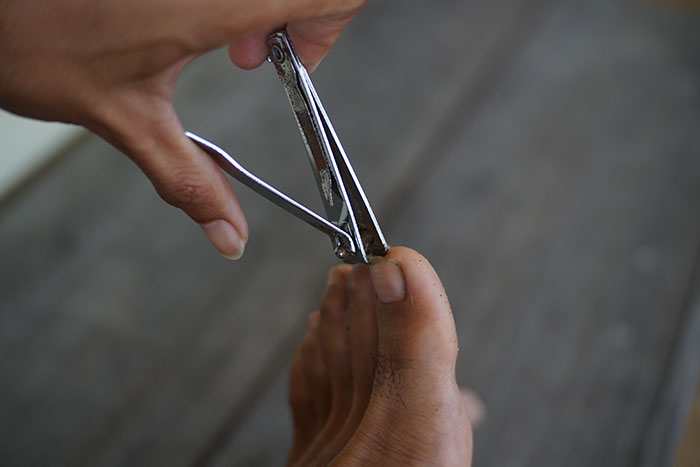 Person clipping toenails possibly relating to ridiculous firing reasons
