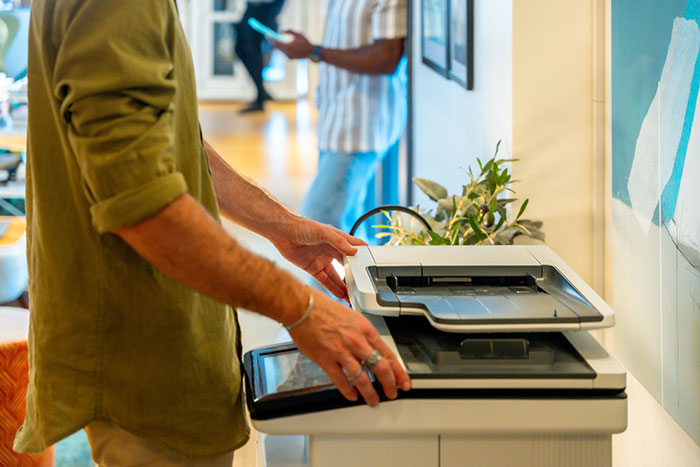 Man using office printer illustrating fired employees workplace situations
